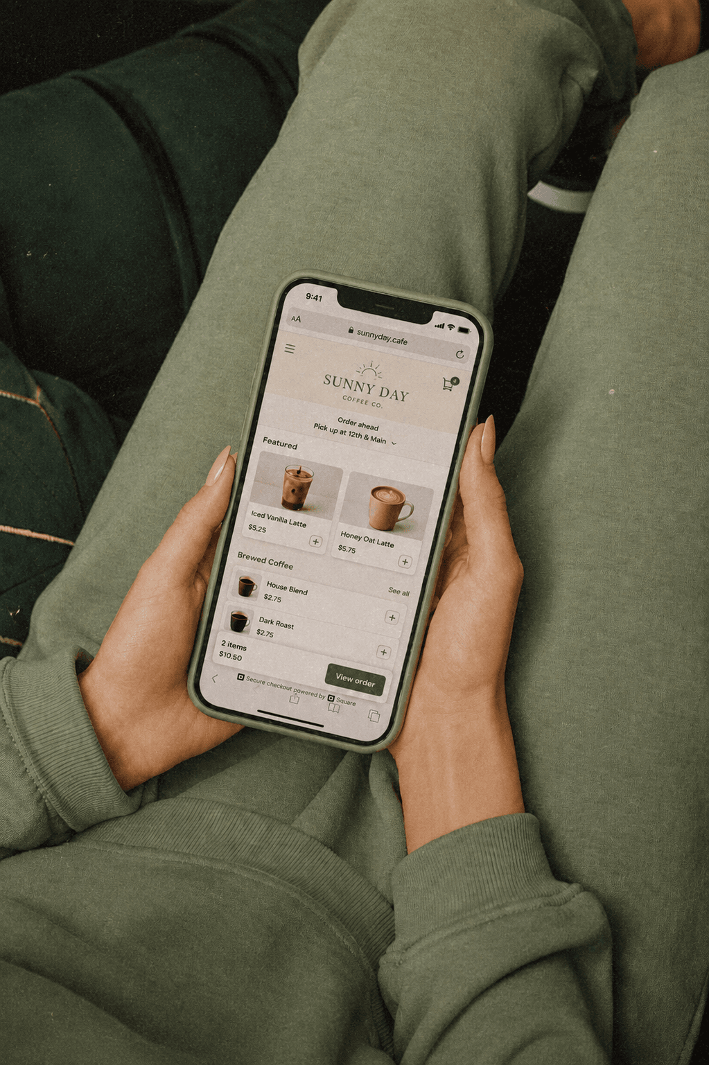 person in green sweatpants ordering coffee from their phone