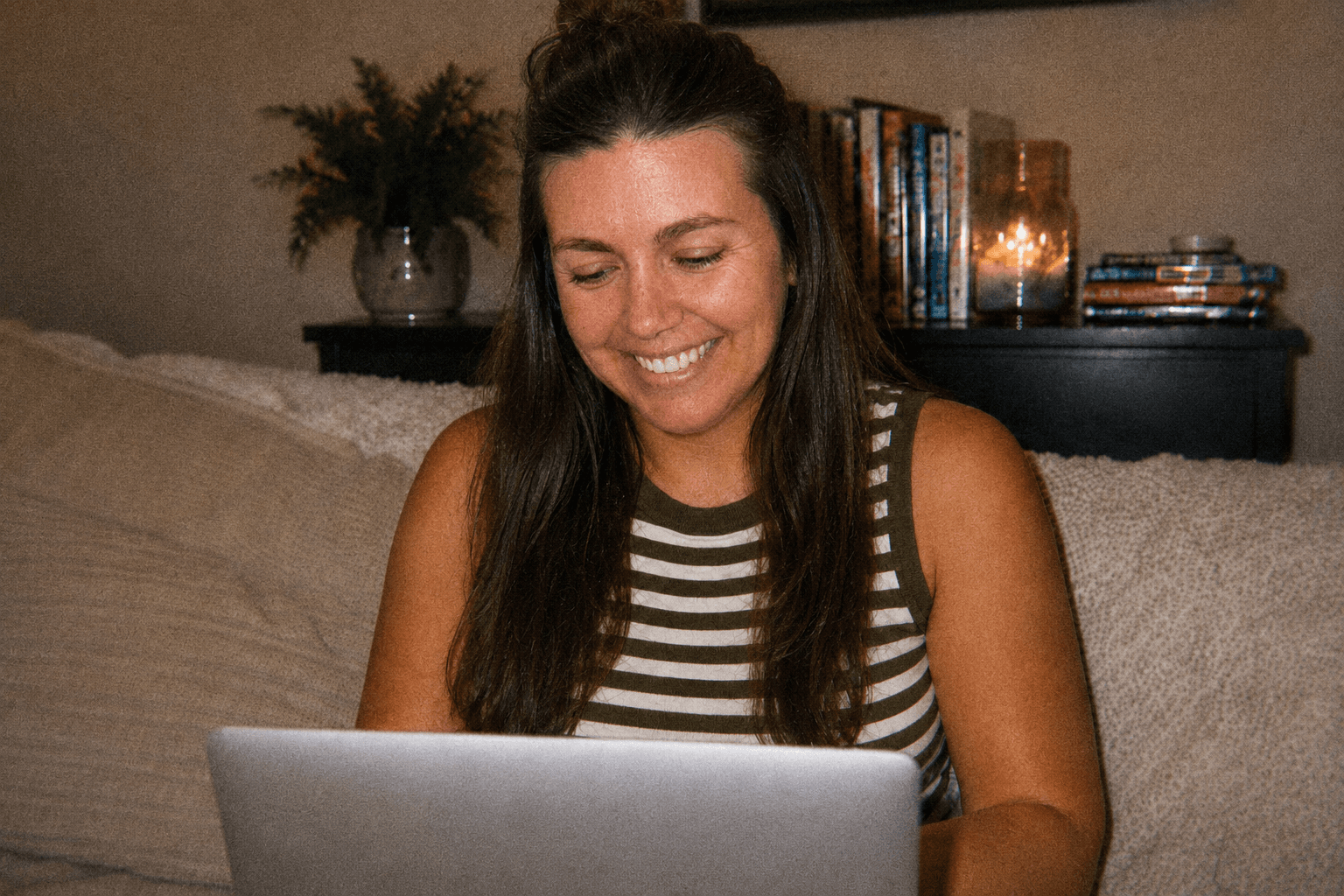 girl sitting on a couch looking at her laptop