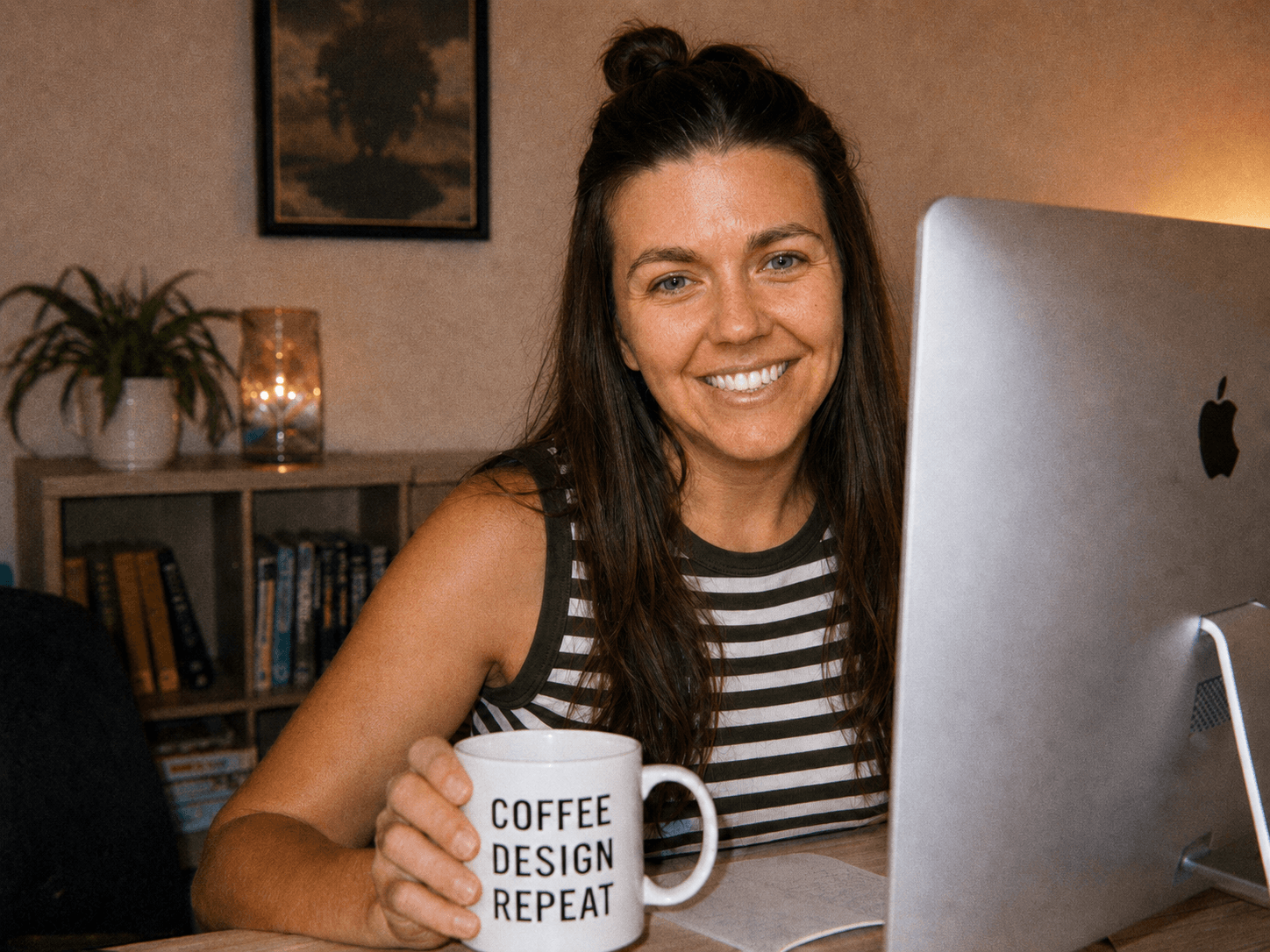 a girl sitting at her computer holding a coffee cup